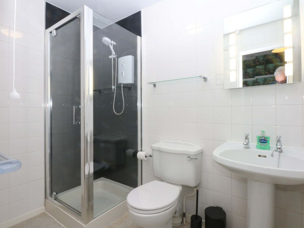 A bathroom with a shower, toilet, and sink at Southbourne Manor in Llandudno