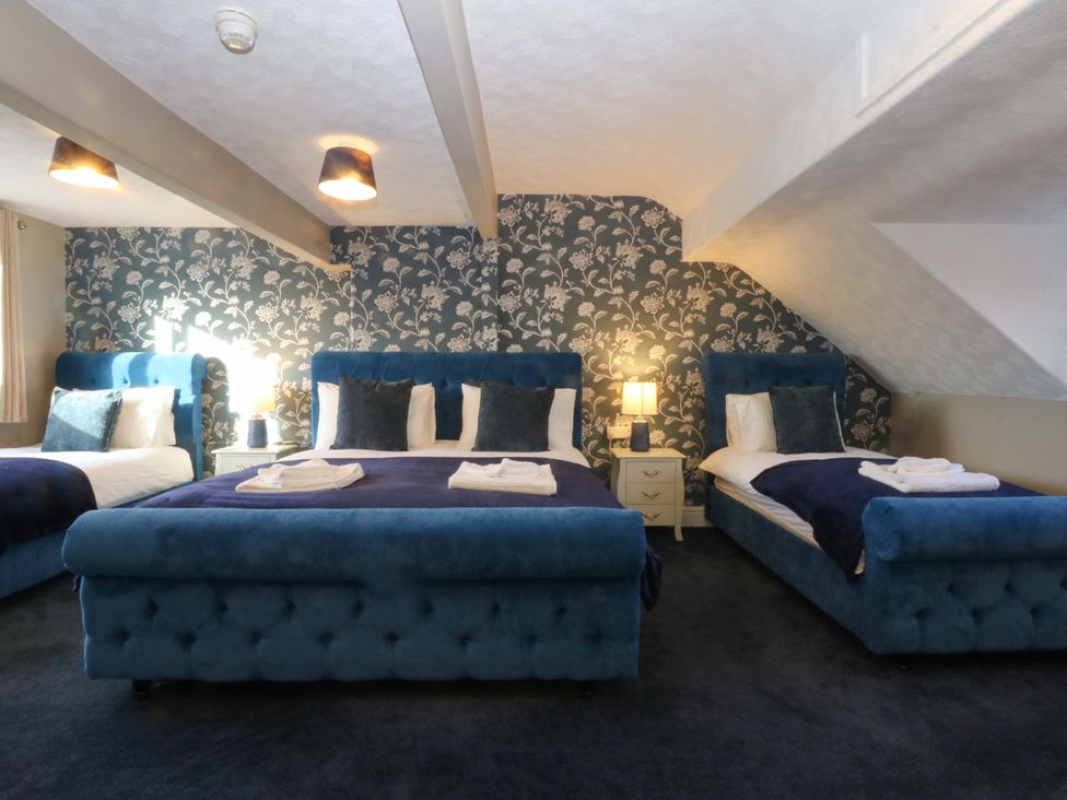 A bedroom with multiple beds and nightstands at Southbourne Manor in Llandudno