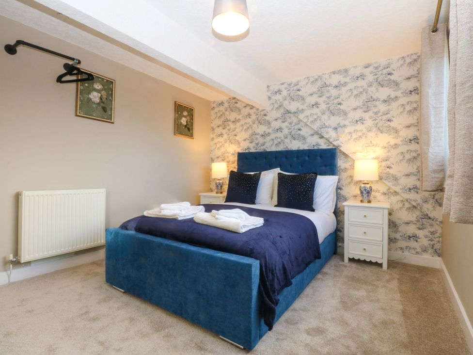 A bedroom with a blue bed and nightstands at Southbourne Manor in Llandudno