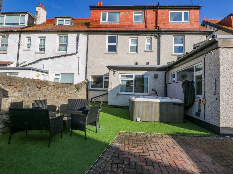 A garden with a hot tub and outdoor furniture at Southbourne Manor in Llandudno