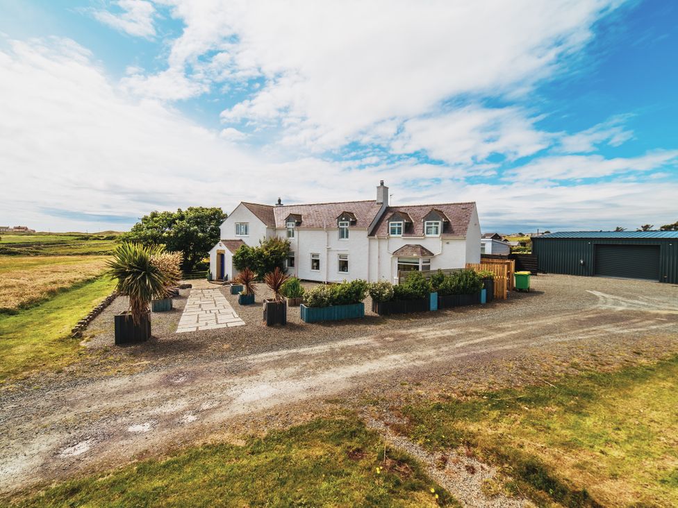 An outdoor view of a house with garden and garage at Glanllyn Bach Llanfaelog