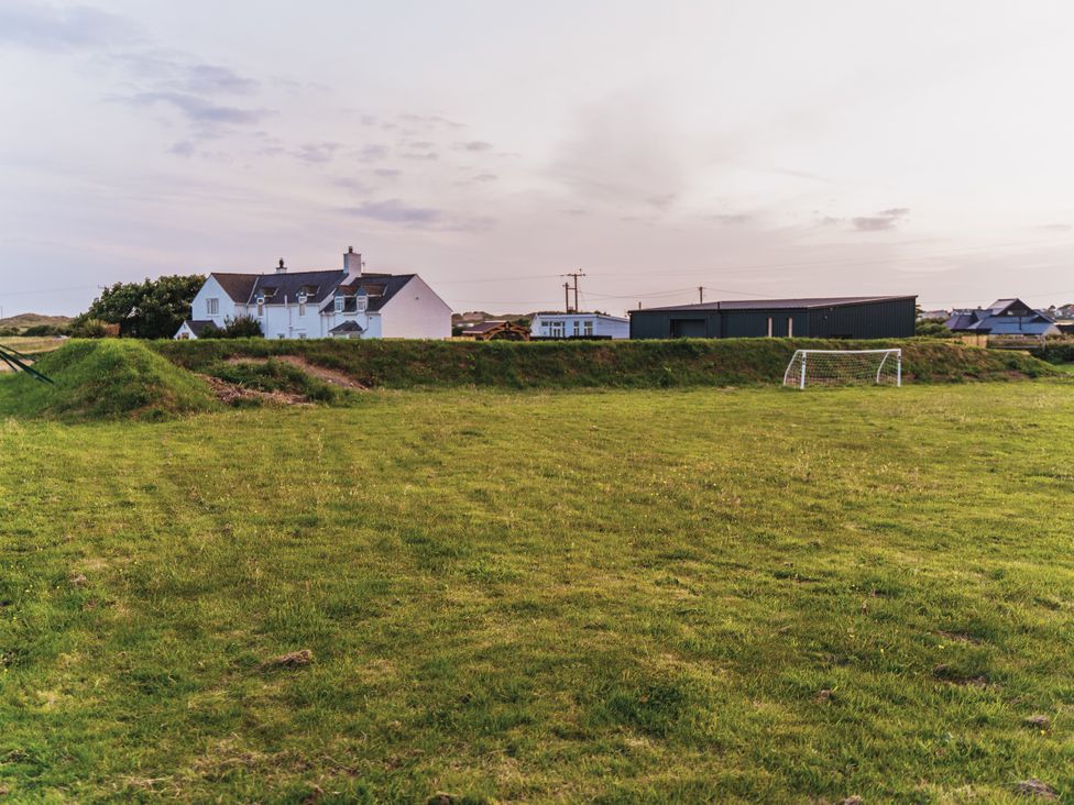 A field with a goal and nearby houses at Glanllyn Bach in Llanfaelog