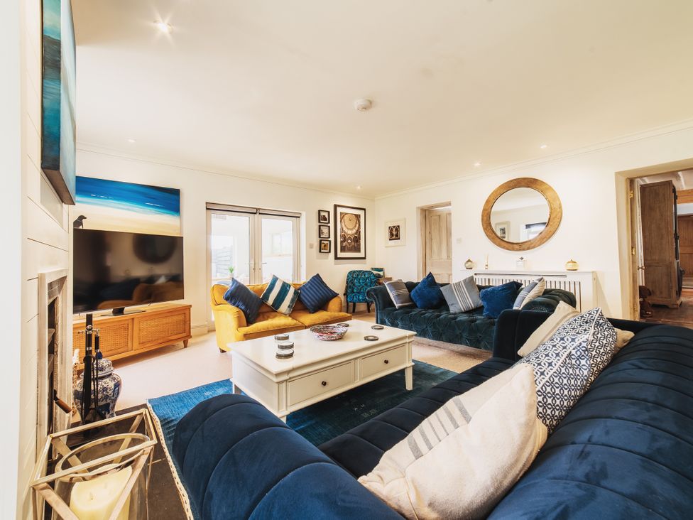 A living room with a sofa and television at Glanllyn Bach in Llanfaelog