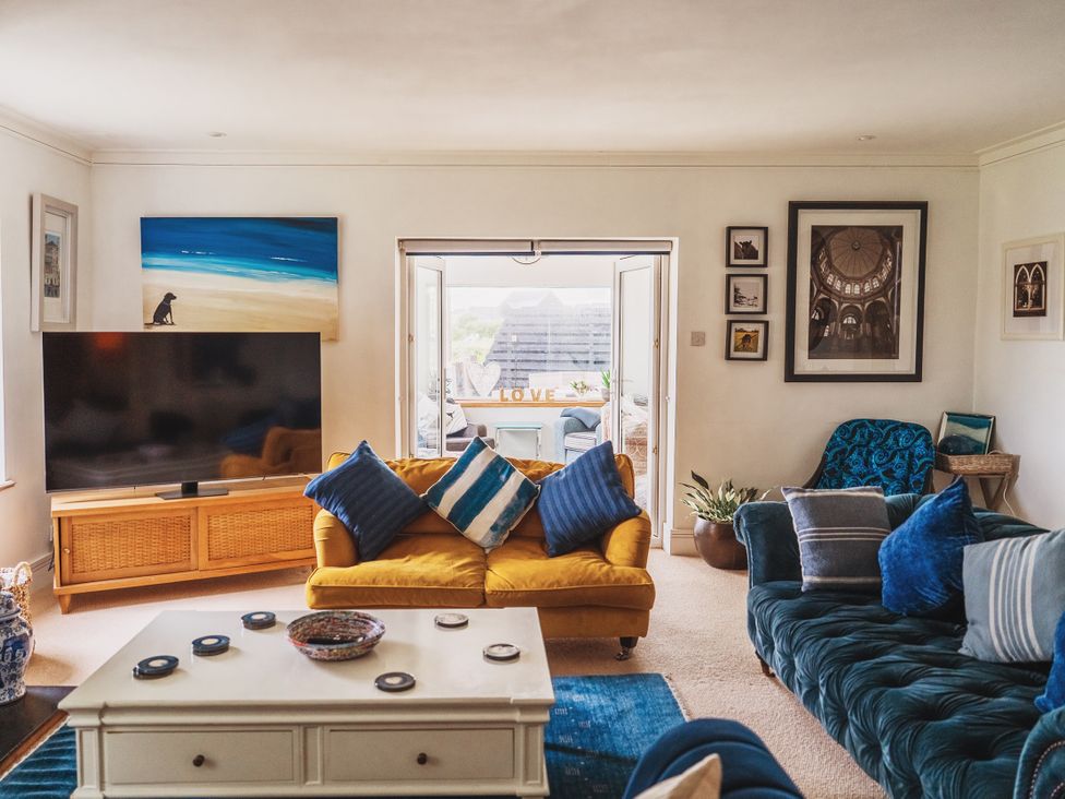 A living room with a sofa and television at Glanllyn Bach in Llanfaelog