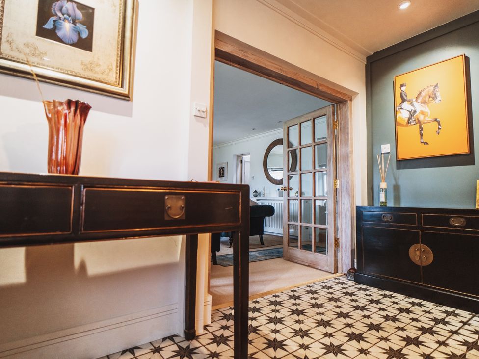A hallway with a console table and a doorway leading to another room at Glanllyn Bach in Llanfaelog