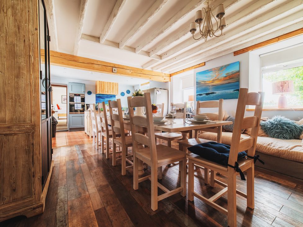 A dining room with a large table and chairs at Glanllyn Bach in Llanfaelog