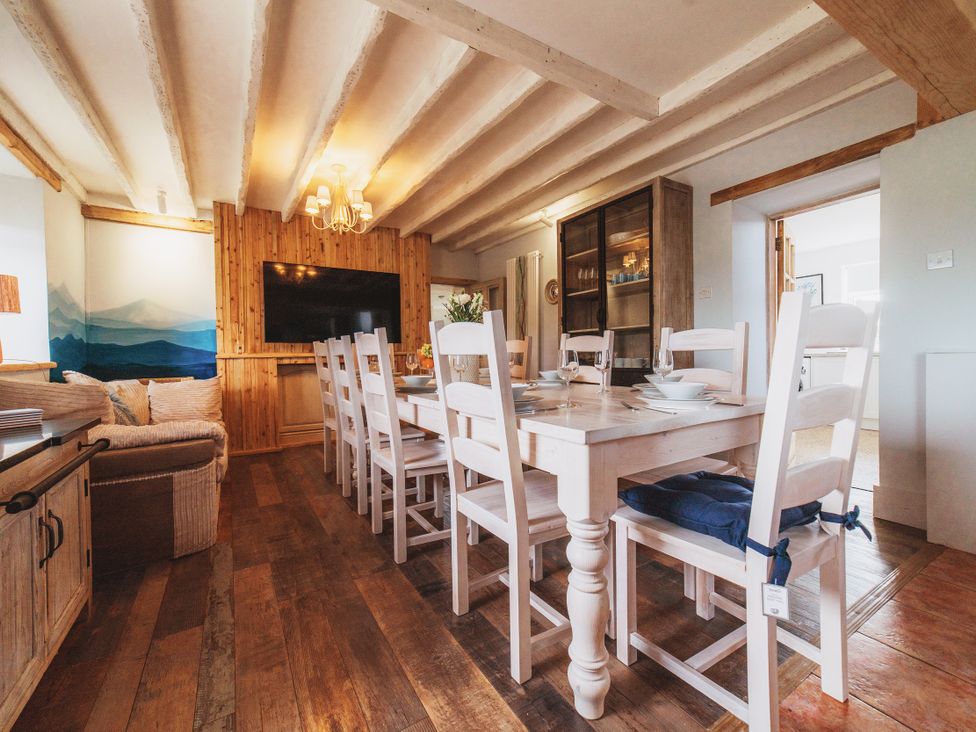 A dining room with a large table and chairs at Glanllyn Bach in Llanfaelog