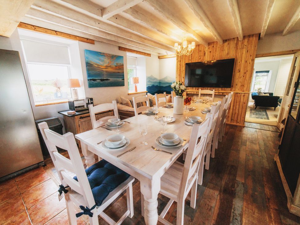 A dining room with a large table and chairs at Glanllyn Bach in Llanfaelog