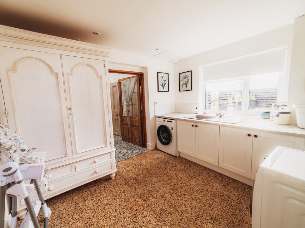 A kitchen with a washing machine and sink at Glanllyn Bach in Llanfaelog