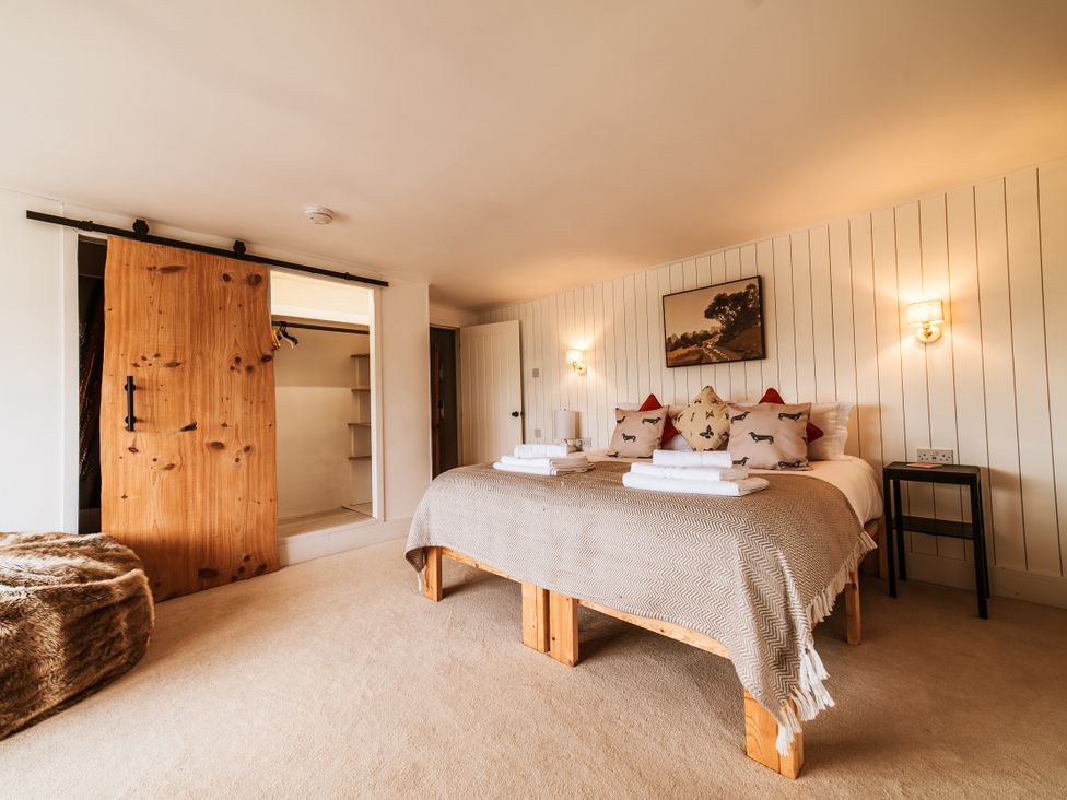 A bedroom with a bed and wardrobe at Glanllyn Bach in Llanfaelog