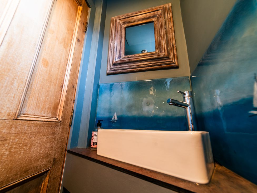 A bathroom with a sink and mirror at Glanllyn Bach in Llanfaelog