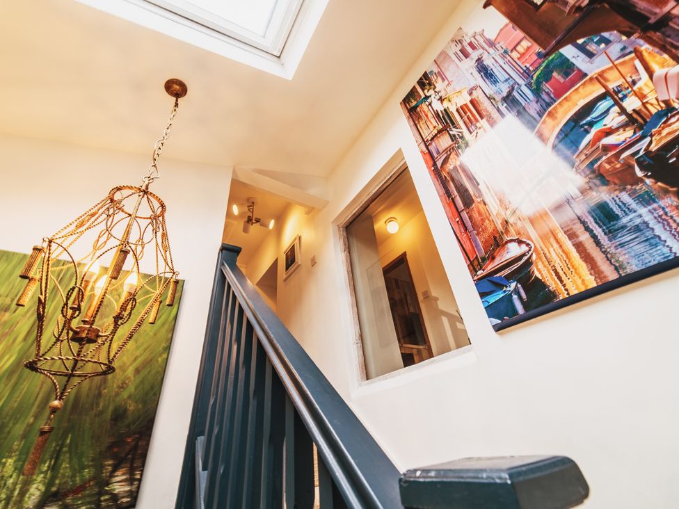 A staircase and chandelier in a hallway at Glanllyn Bach in Llanfaelog