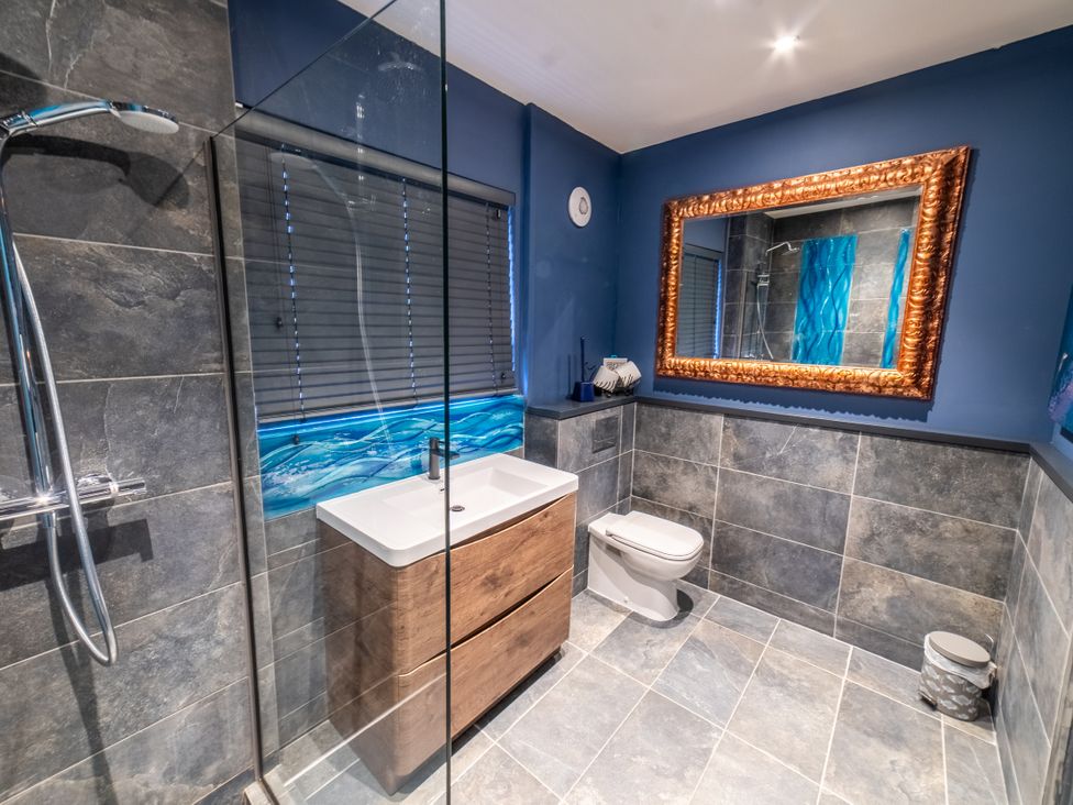 A bathroom with a shower, sink, and toilet at Glanllyn Bach in Llanfaelog