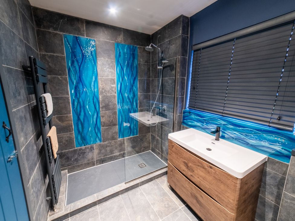 A bathroom with a shower and sink at Glanllyn Bach in Llanfaelog