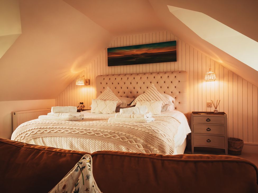 A bedroom with a bed and bedside lamps at Glanllyn Bach in Llanfaelog