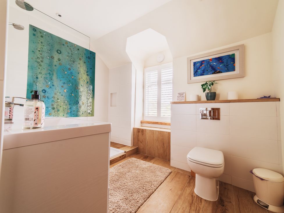A bathroom with a bathtub, toilet, and sink at Glanllyn Bach Llanfaelog