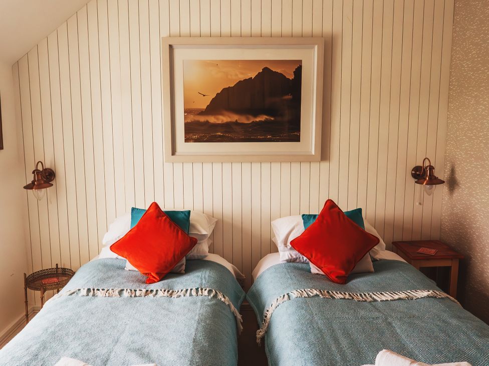 A bedroom with two beds arranged side by side at Glanllyn Bach Llanfaelog