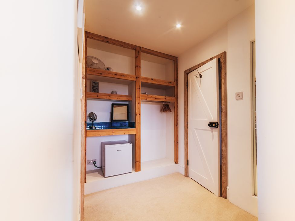 A storage room with shelves and appliances at Glanllyn Bach in Llanfaelog
