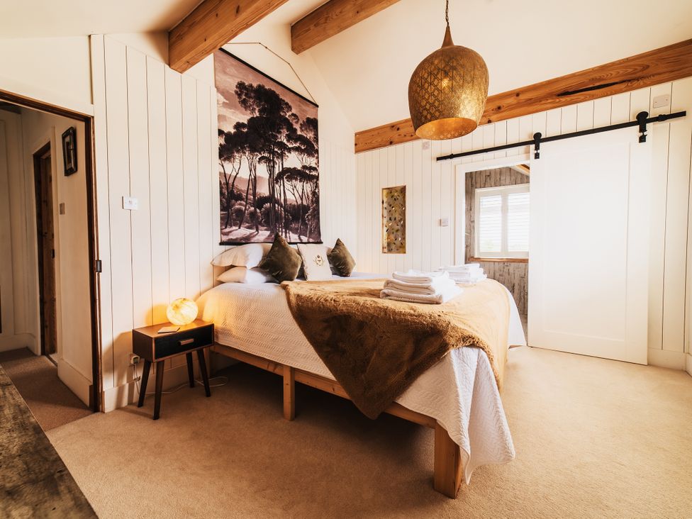 A bedroom with a bed and bedside table at Glanllyn Bach in Llanfaelog