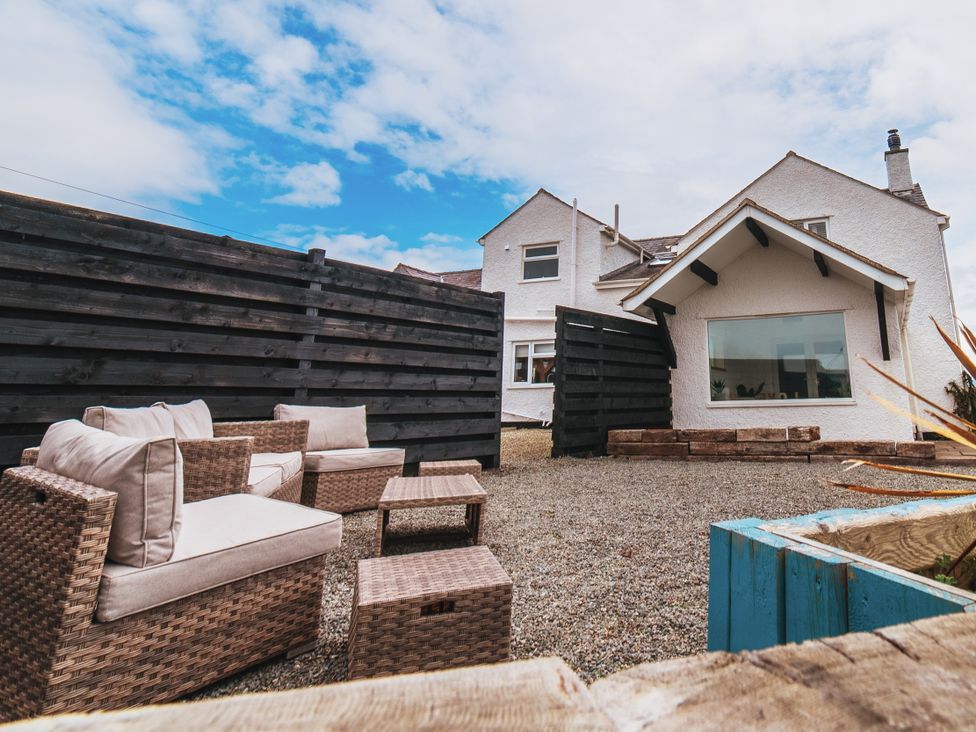 A garden with outdoor seating near a house at Glanllyn Bach in Llanfaelog