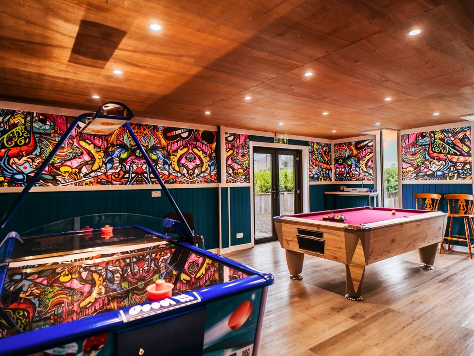 A games room with an air hockey table and a pool table at Glanllyn Bach in Llanfaelog