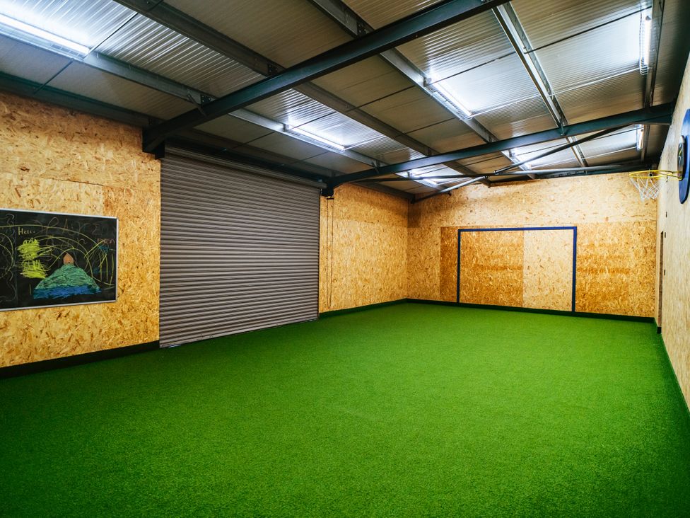 An indoor sports area with artificial grass and a goal structure at Glanllyn Bach Llanfaelog