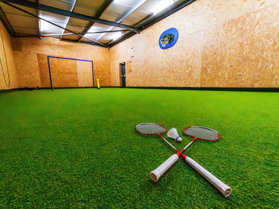 An indoor sports hall with badminton rackets and accessories at Glanllyn Bach Llanfaelog