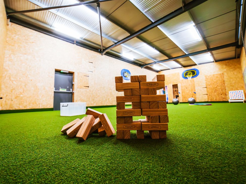 An indoor activity space with wooden blocks and exercise balls at Glanllyn Bach in Llanfaelog