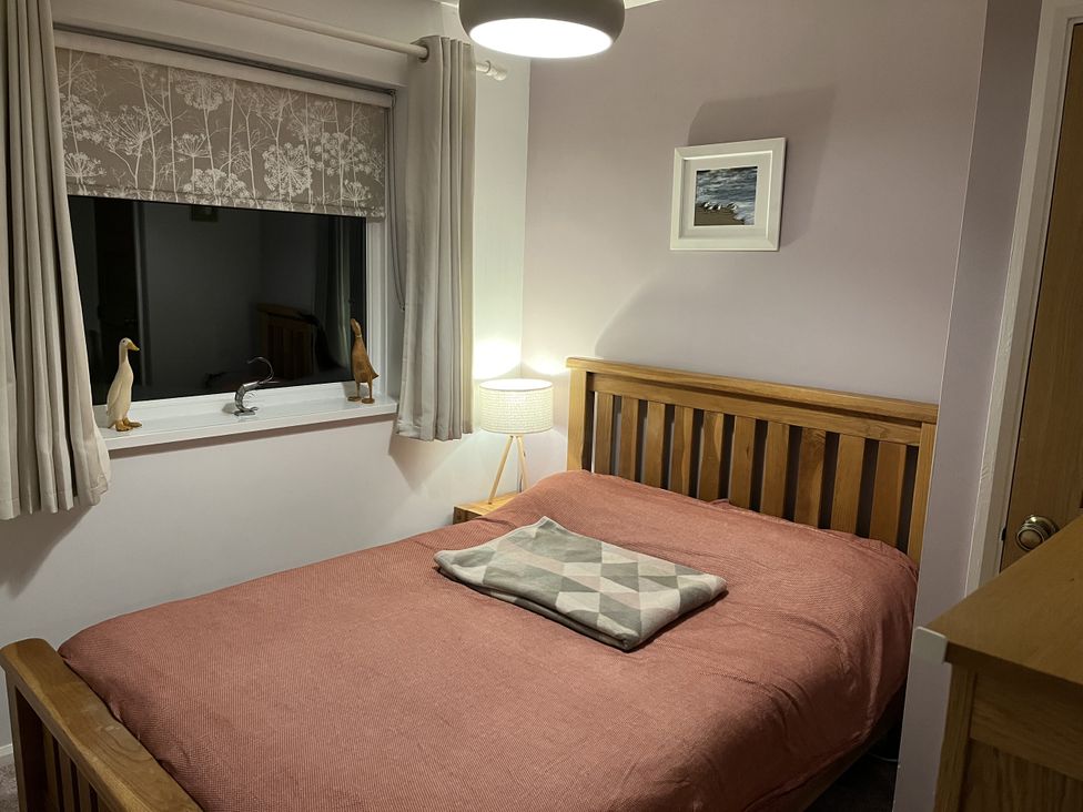 A bedroom with a bed and window at The Lobster Pot in Oxwich