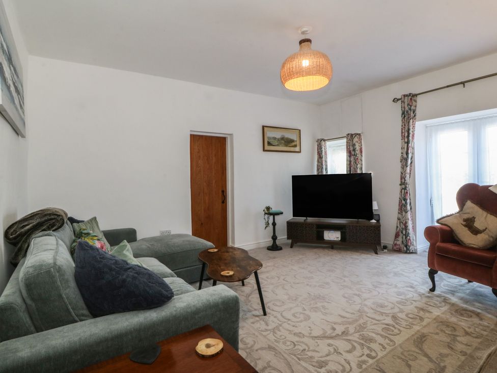 A living room with a sofa and coffee table at Tan Y Merddyn in Ceunant near Llanrug