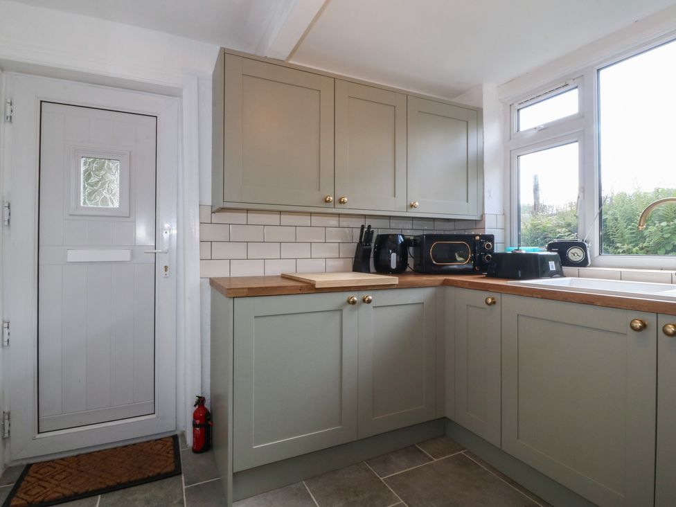 A kitchen with cabinets and appliances at Tan Y Merddyn in Ceunant near Llanrug