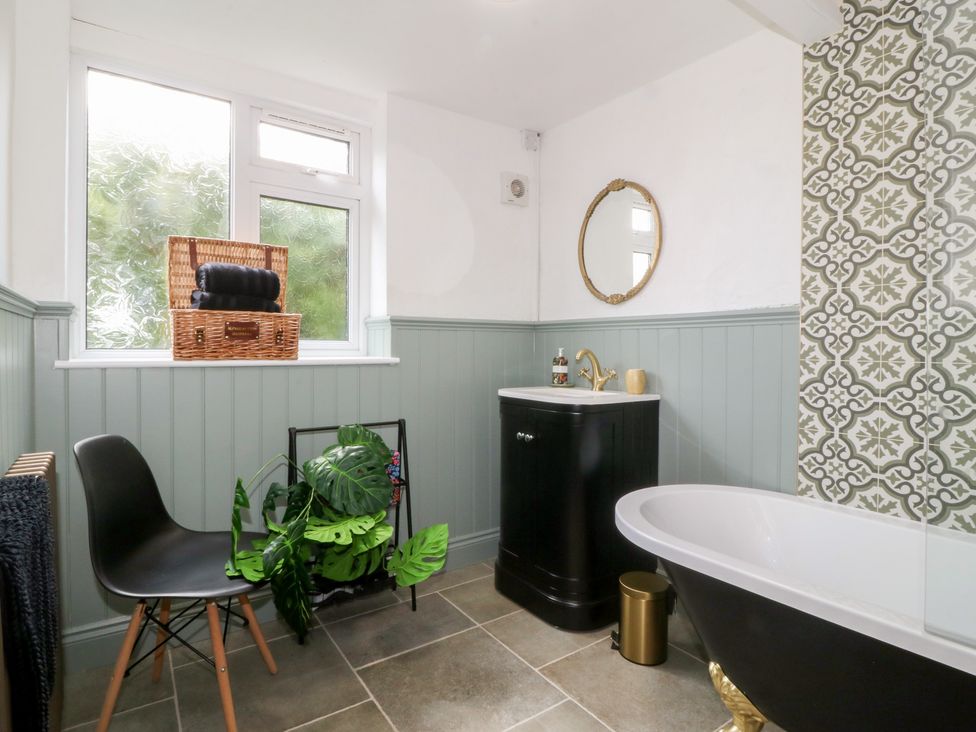 A bathroom with a bathtub and vanity at Tan Y Merddyn in Ceunant near Llanrug
