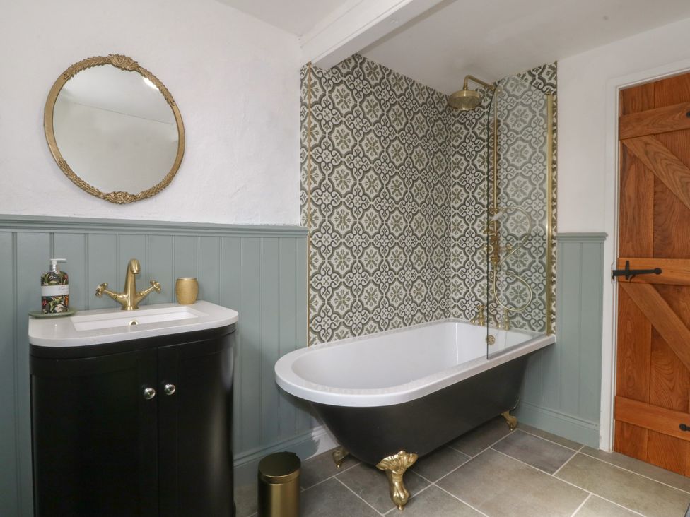A bathroom with a bathtub, sink, and shower at Tan Y Merddyn in Ceunant near Llanrug