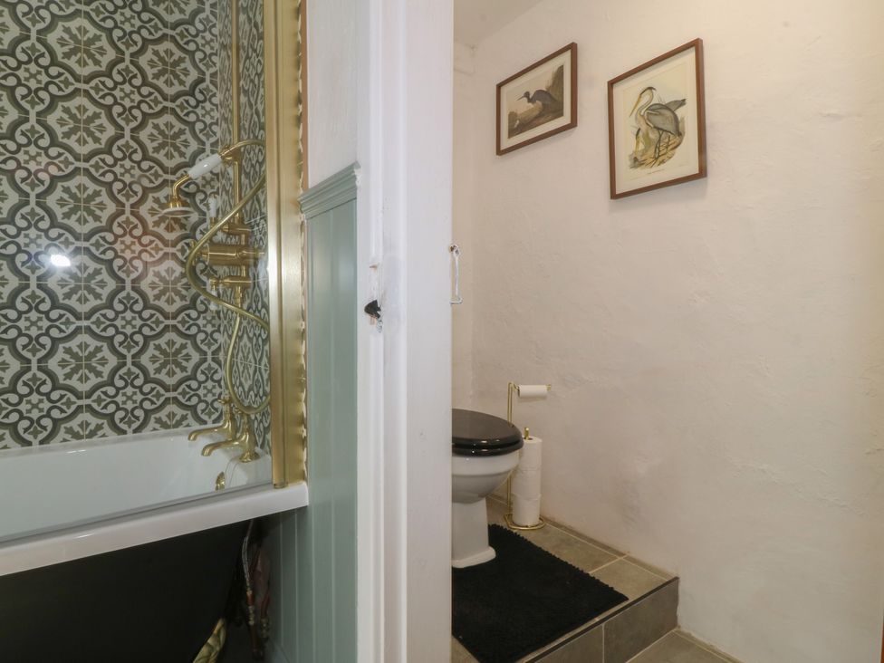 A bathroom with a bathtub and toilet at Tan Y Merddyn in Ceunant near Llanrug