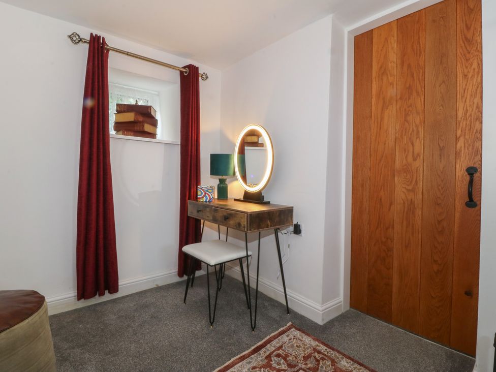 A bedroom with a vanity desk and a mirror at Tan Y Merddyn in Ceunant near Llanrug