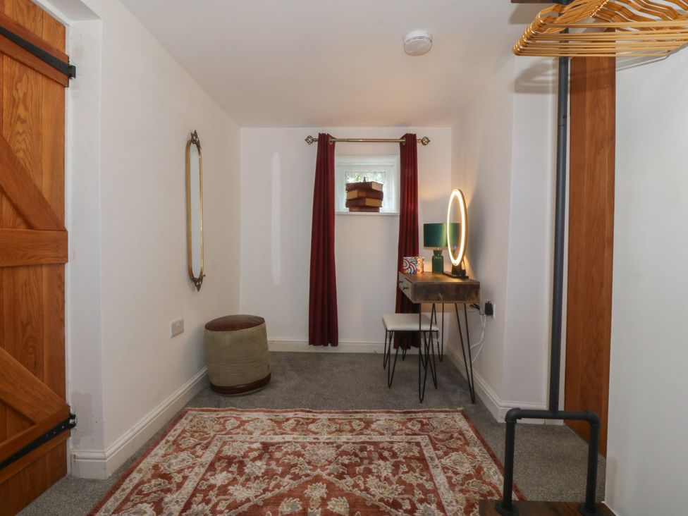 A room with a desk and mirror at Tan Y Merddyn in Ceunant near Llanrug