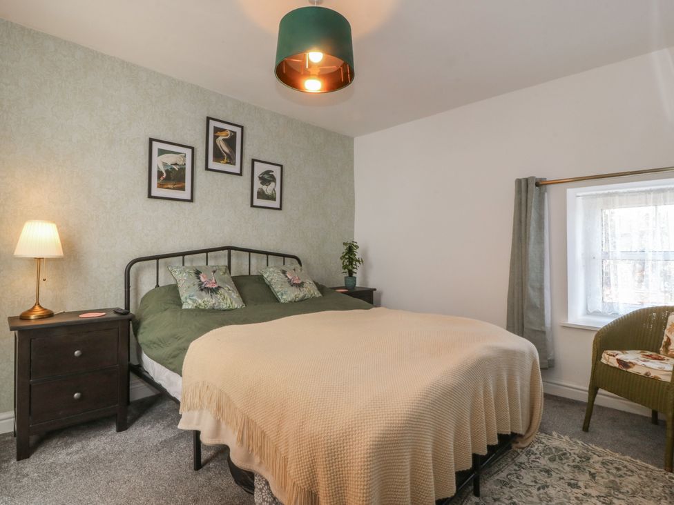 A bedroom with a bed and bedside lamp at Tan Y Merddyn Ceunant near Llanrug
