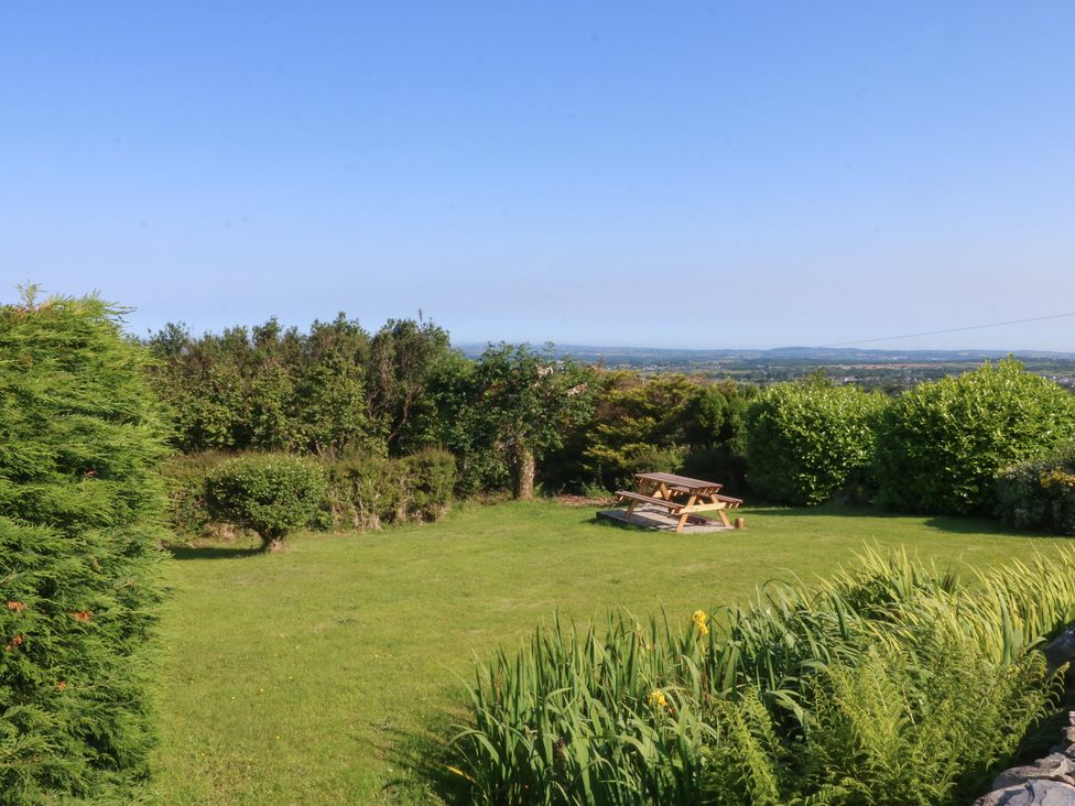 A garden with a picnic table and trees at Tan Y Merddyn Ceunant near Llanrug