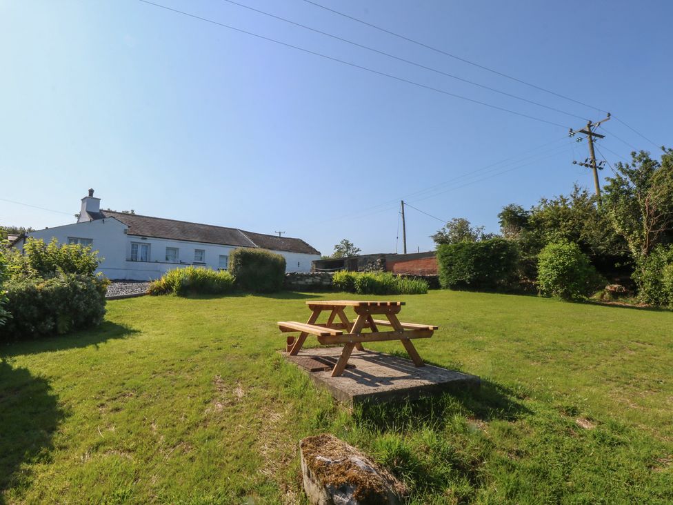 A garden with a picnic table and a house in the background at Tan Y Merddyn Ceunant near Llanrug
