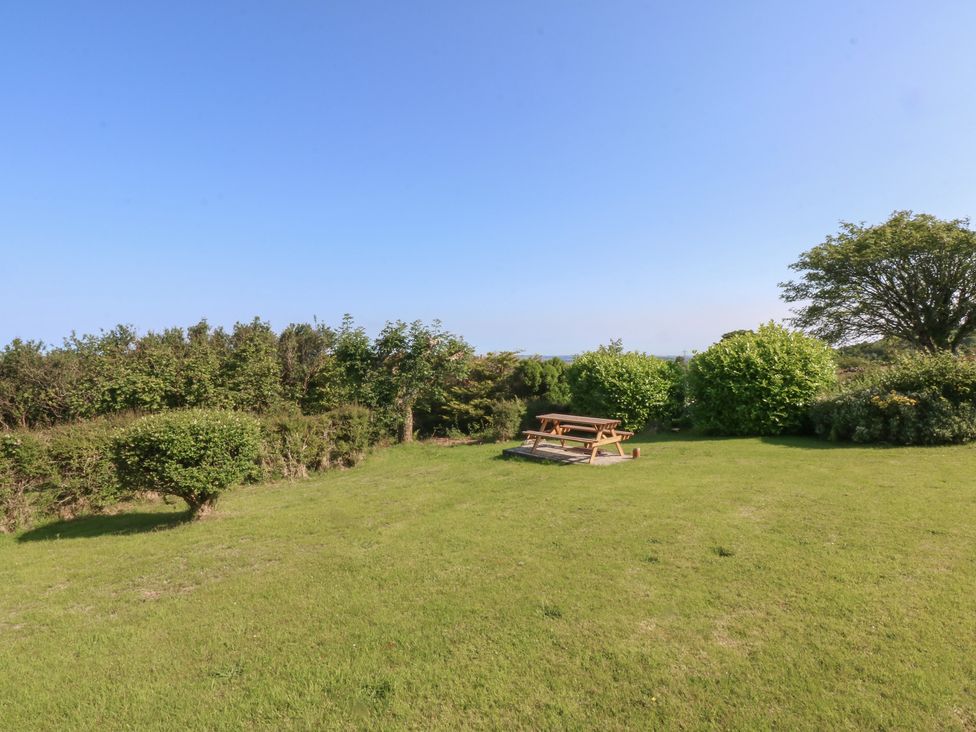 A garden with a picnic table and shrubs at Tan Y Merddyn Ceunant near Llanrug