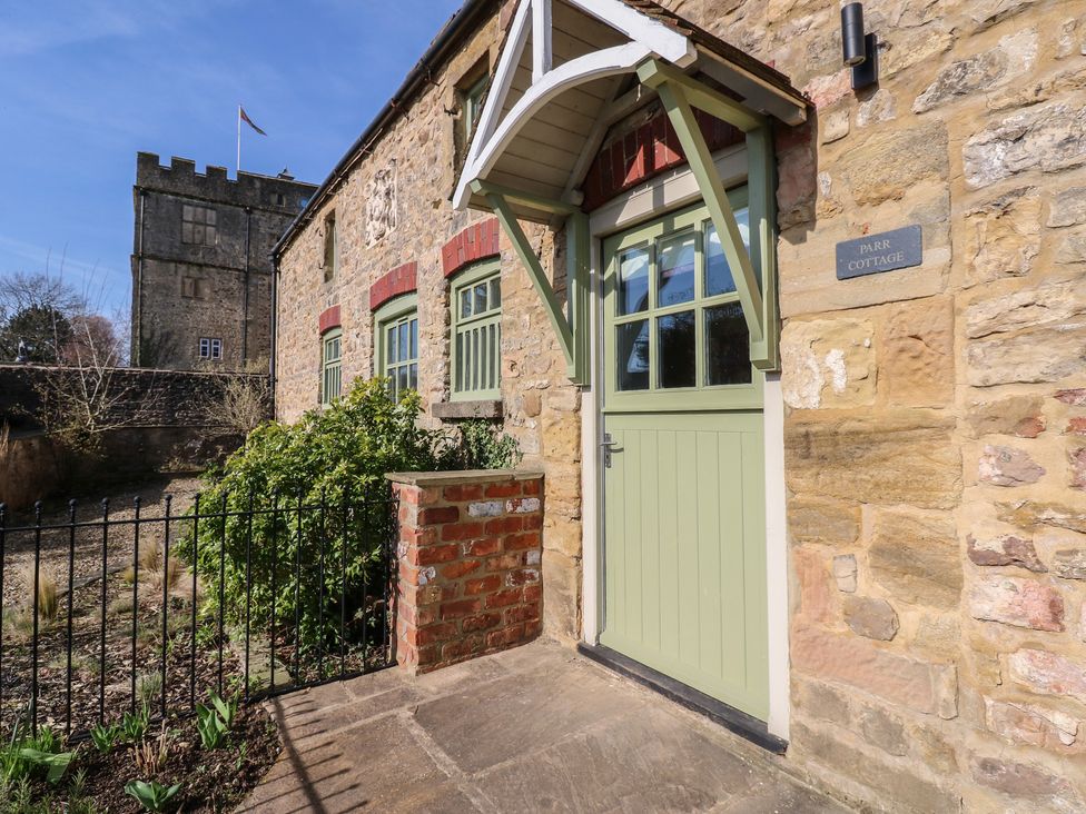The entrance of Parr Cottage with stone walls and green door at Parr Cottage Snape near Bedale