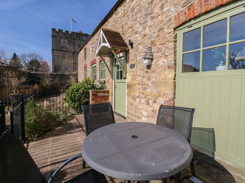 An outdoor seating area with a table and chairs at Parr Cottage in Snape near Bedale