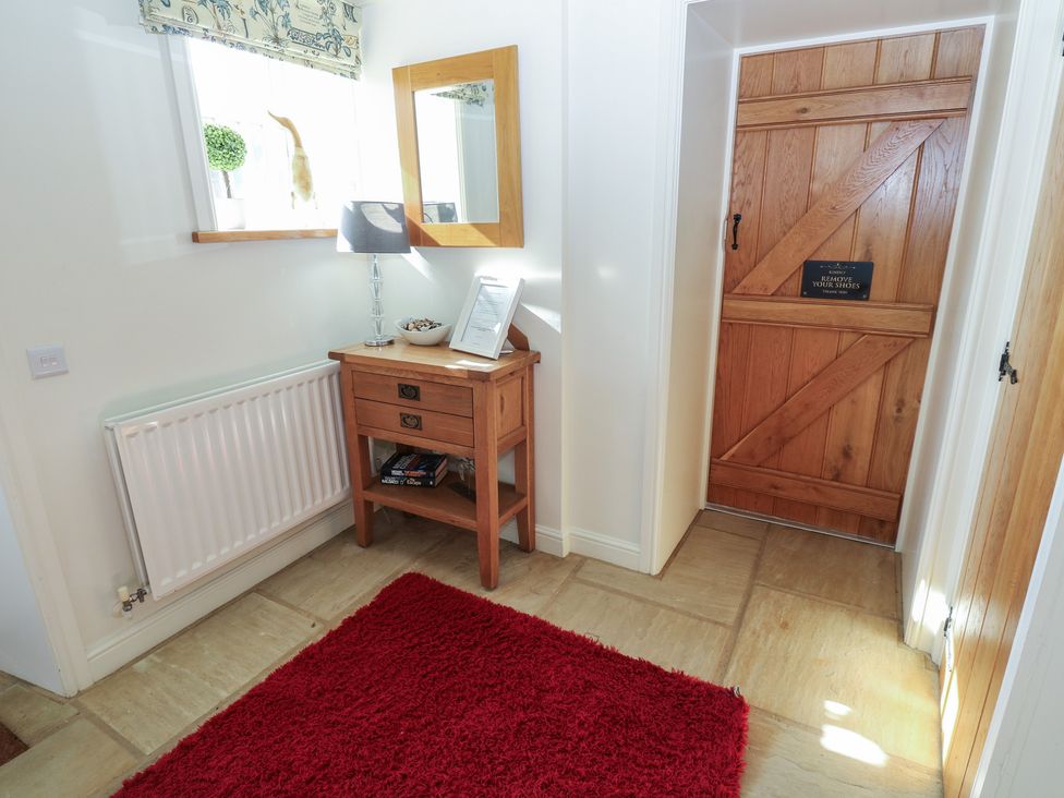 A hallway with a table and lamp at Parr Cottage in Snape near Bedale