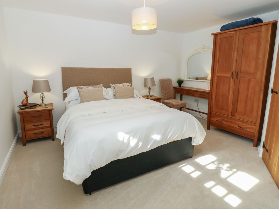 A bedroom with a bed and nightstand at Parr Cottage Snape near Bedale