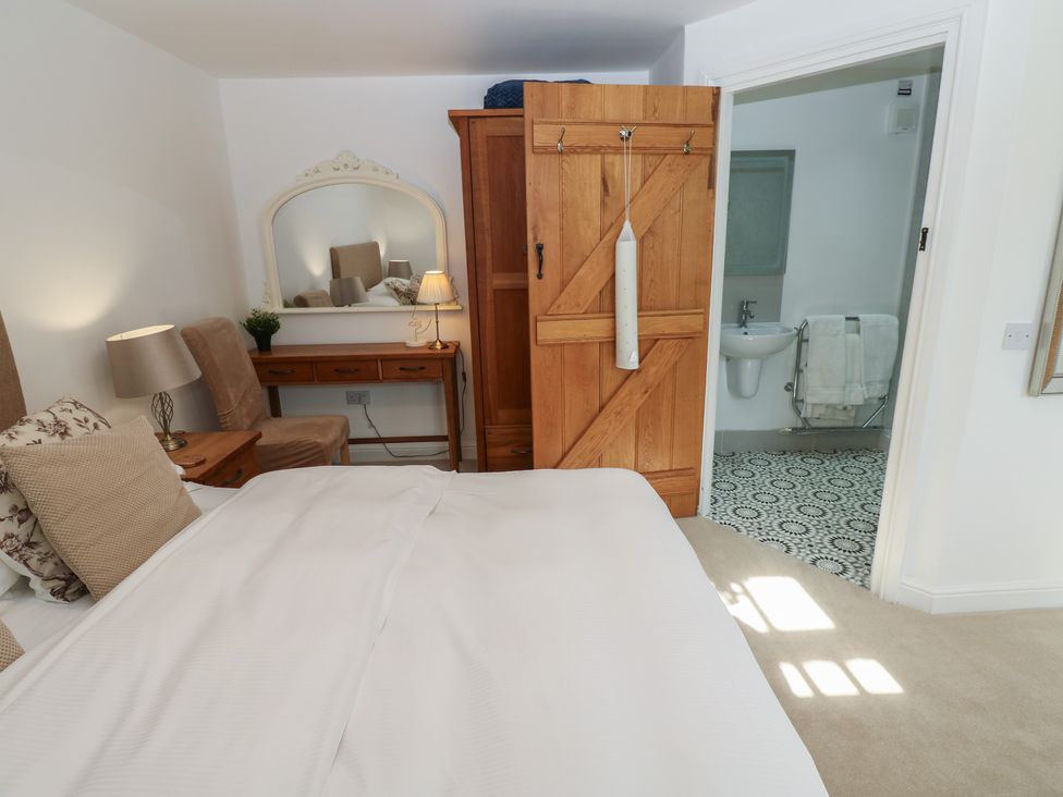 A bedroom with a bed, desk, and wardrobe at Parr Cottage Snape near Bedale