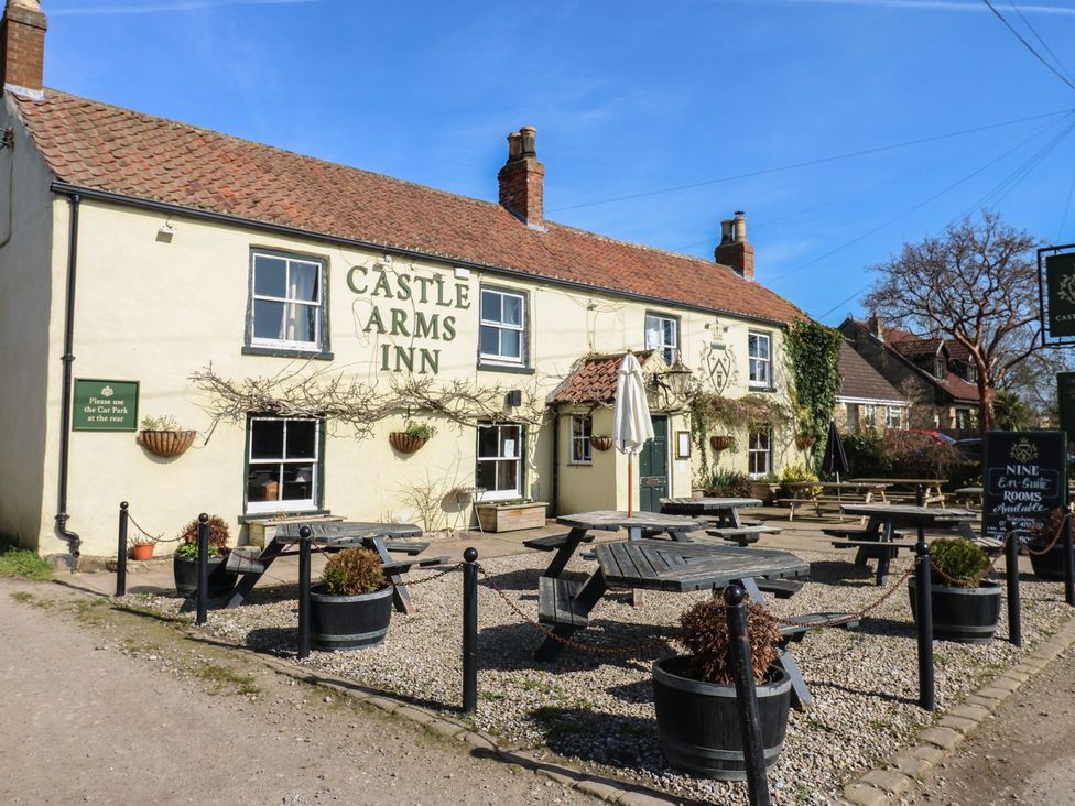 An outdoor seating area of a pub with tables at Castle Arms Inn in Snape near Bedale