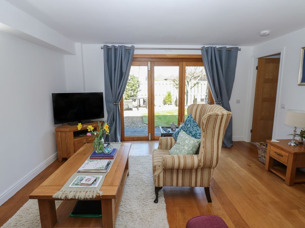 A living room with a television and armchair at The Cart House Snape near Bedale
