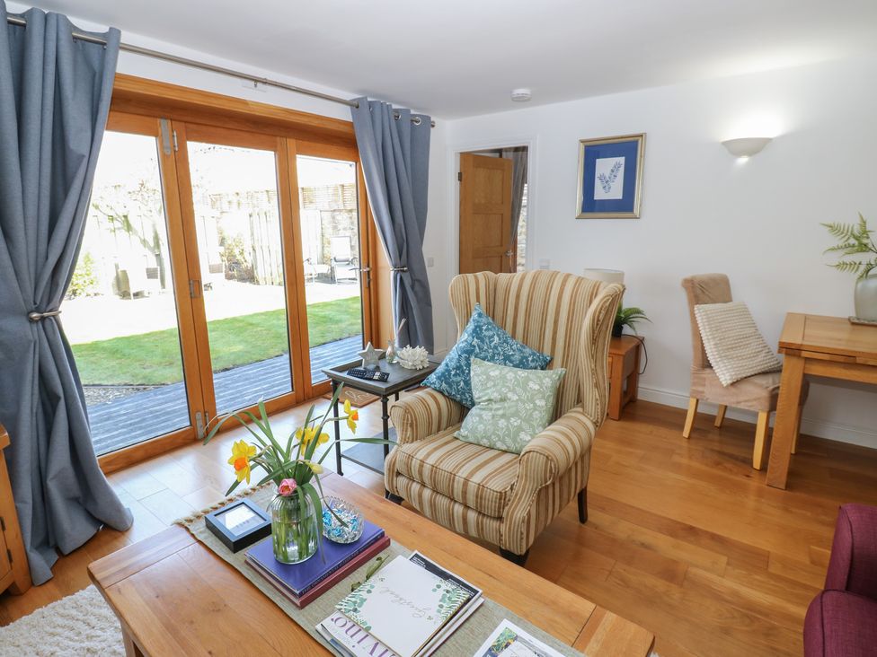 A living room with double doors opening to garden at The Cart House Snape near Bedale