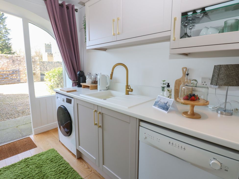 A kitchen with a sink and washing machine at The Cart House in Snape near Bedale