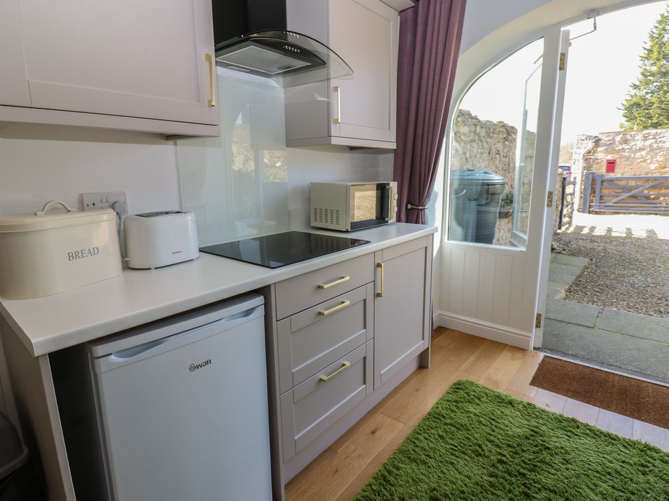 A kitchen with refrigerator, microwave, toaster, and oven at The Cart House in Snape near Bedale